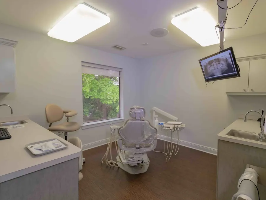A treatment room at Bayou Dental, with a window onto the trees.